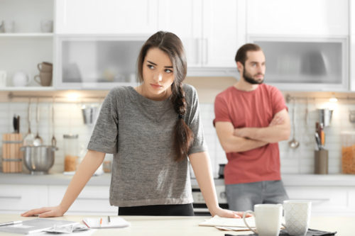 Young couple ignoring each other after having argument in kitchen
